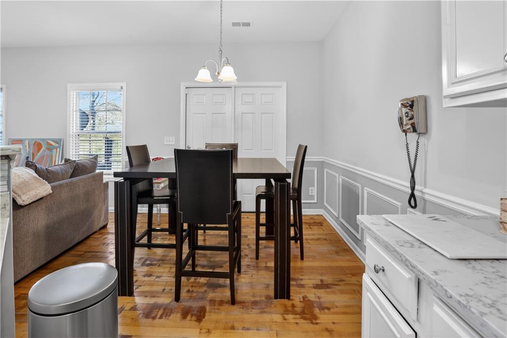 2555 Flat Shoals Road, Unit 1304 Atlanta, GA 30349 - Photo 6 of 27 a view of a dining room with furniture a chandelier and wooden floor