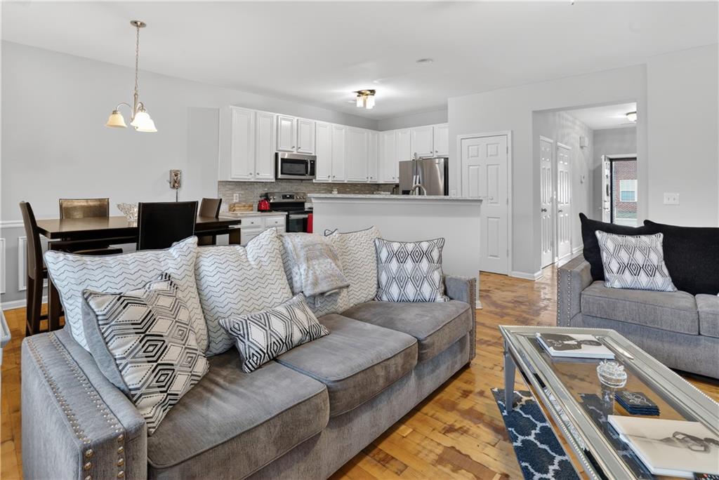 2555 Flat Shoals Road, Unit 1304 Atlanta, GA 30349 - Photo 9 of 27 a living room with furniture a kitchen island with kitchen countertops and a stove