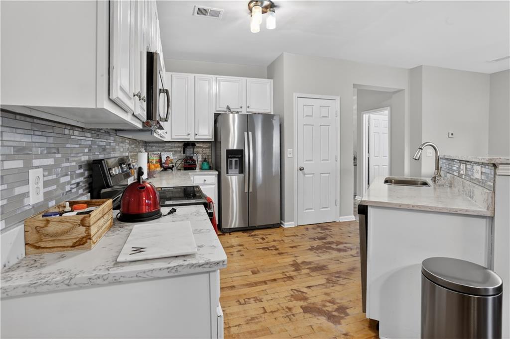 2555 Flat Shoals Road, Unit 1304 Atlanta, GA 30349 - Photo 10 of 27 a kitchen with stainless steel appliances granite countertop a sink refrigerator stove and microwave
