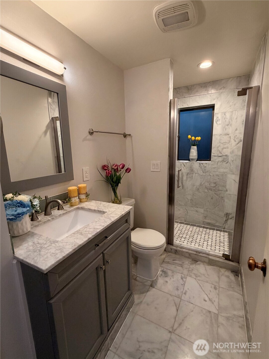 3217 East Madison Street Seattle, WA 98112 - Photo 10 of 40 a bathroom with a granite countertop sink toilet and mirror