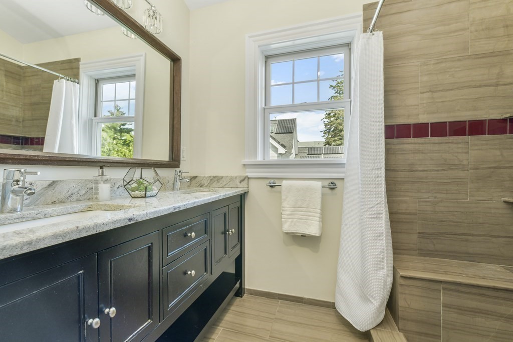 46 Spring Street, Unit 2 Somerville, MA 02143 - Photo 13 of 22 a bathroom with a granite countertop sink and a mirror