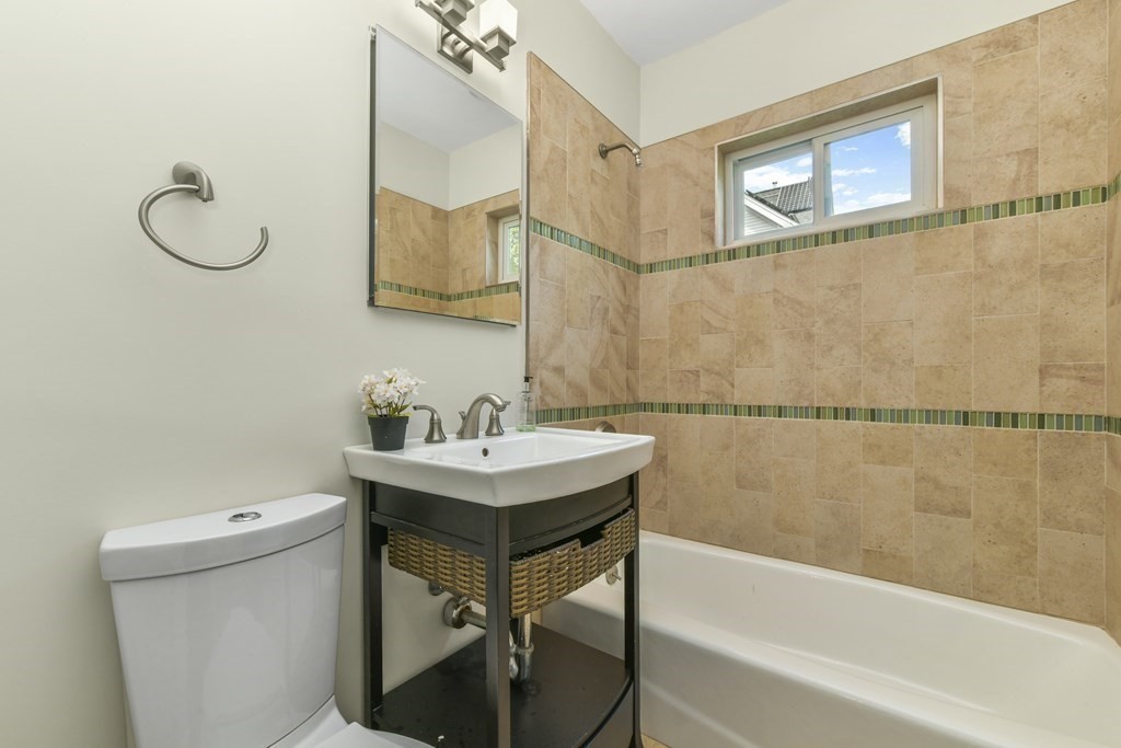 46 Spring Street, Unit 2 Somerville, MA 02143 - Photo 18 of 22 a bathroom with a sink a toilet and mirror