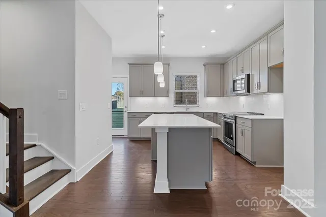 a kitchen with a sink a stove a refrigerator and white cabinets
