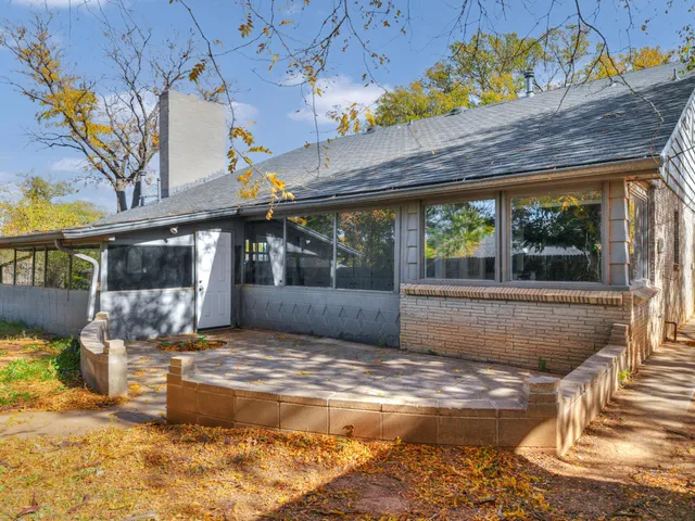 a view of a house with backyard and sitting area