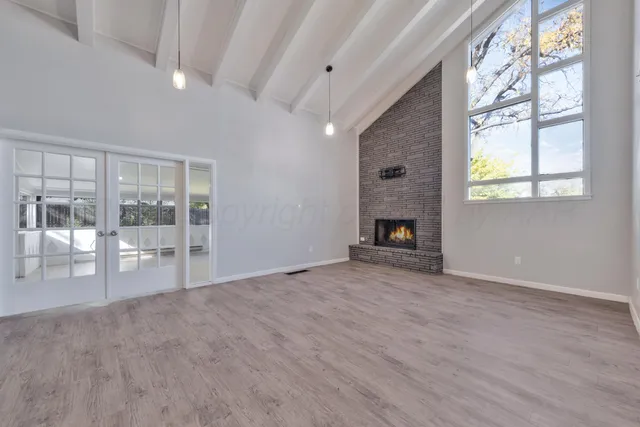 a view of an empty room with a fireplace and a window
