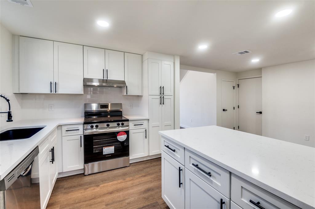 Kitchen featuring stainless steel appliances, a sink, recessed lighting, under cabinet range hood, and tasteful backsplash