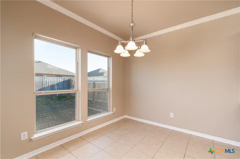 a view of a livingroom with a chandelier fan and a large window