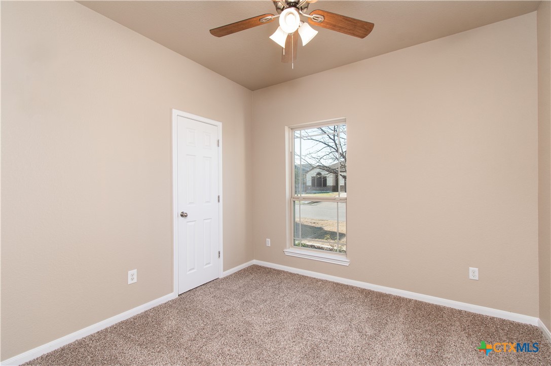8020 Hawthorn Temple, TX 76502 - Photo 2 of 21 an empty room with windows and chandelier fan