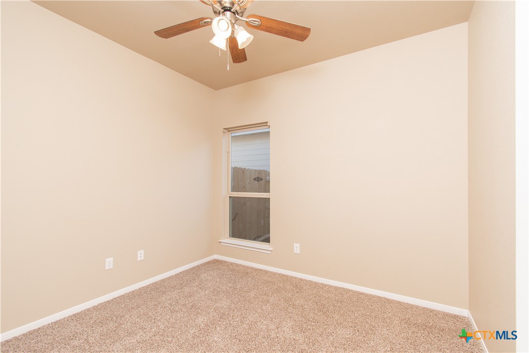 8020 Hawthorn Temple, TX 76502 - Photo 8 of 21 an empty room with a chandelier fan and windows