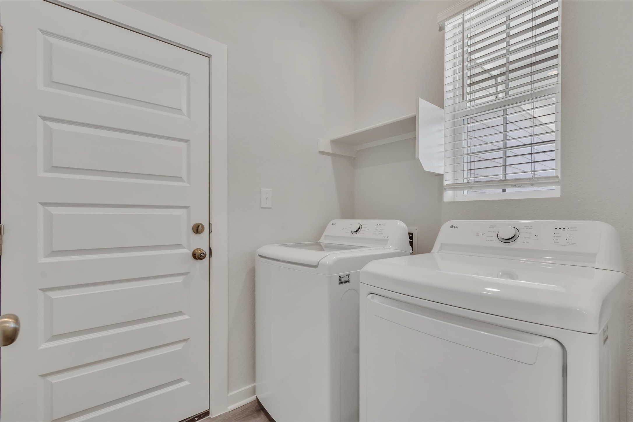 228 Bendecido Loop Elgin, TX 78621 - Photo 10 of 16 Functional laundry room equipped with contemporary appliances and practical shelving for storage.
