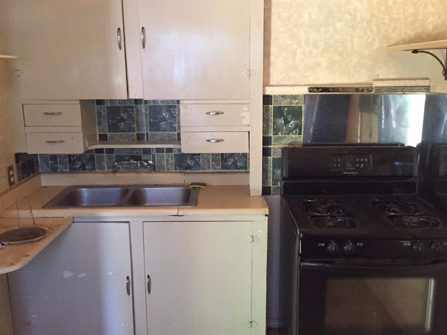 465 Riverside Avenue Gold Hill, OR 97525 - Photo 15 of 26 a kitchen with a sink a stove and a microwave