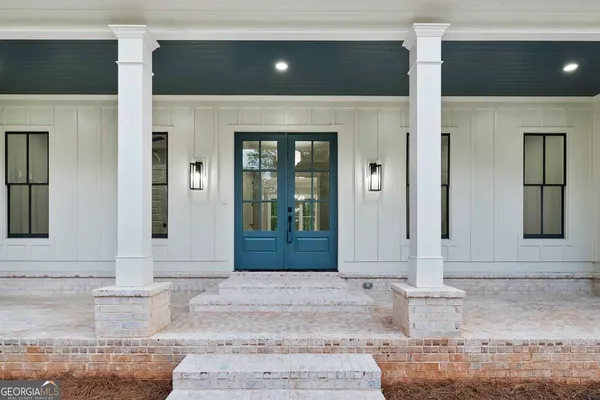 a view of an empty room with wooden floor fireplace and a window