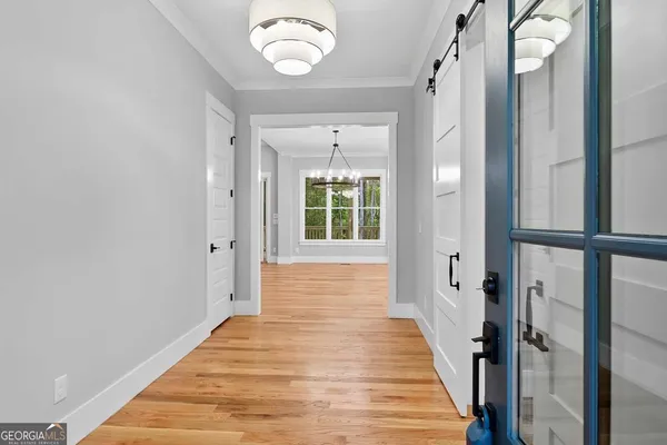 a view of a hallway with wooden floor and staircase
