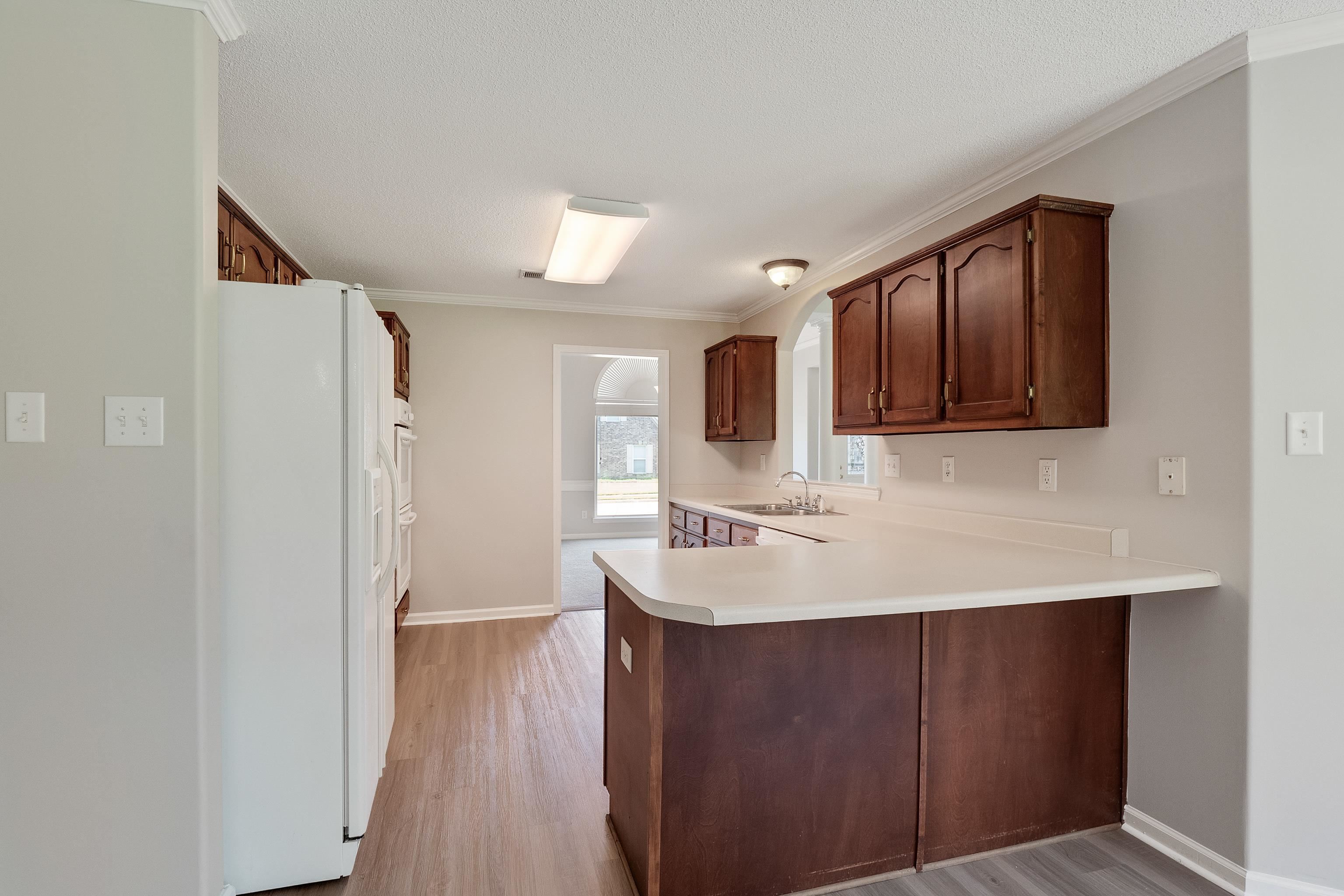 1171 Macon Hall Road Cordova, TN 38018 - Photo 11 of 35 a kitchen with a sink a refrigerator and wooden floor