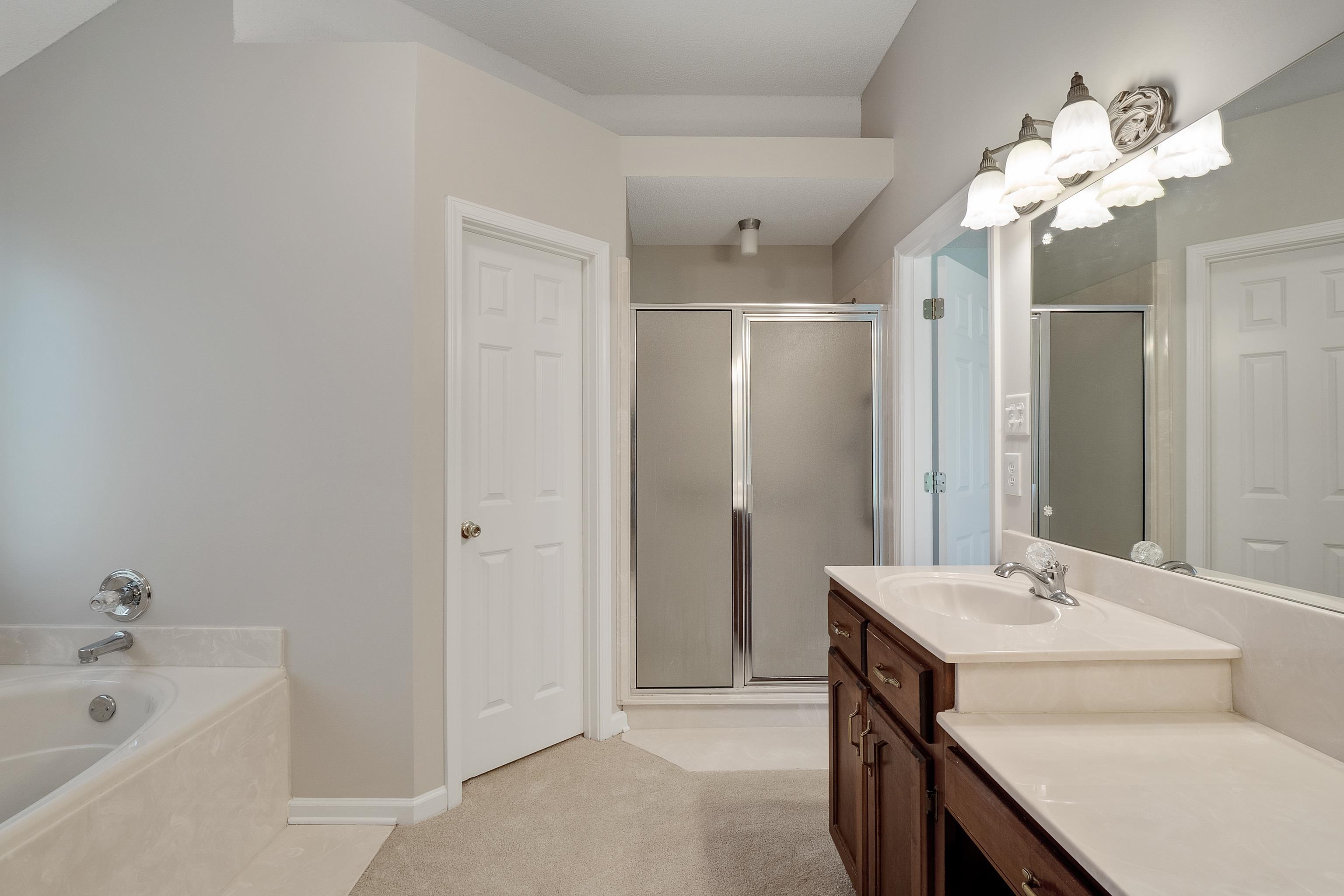 1171 Macon Hall Road Cordova, TN 38018 - Photo 19 of 35 a bathroom with a tub sink and mirror
