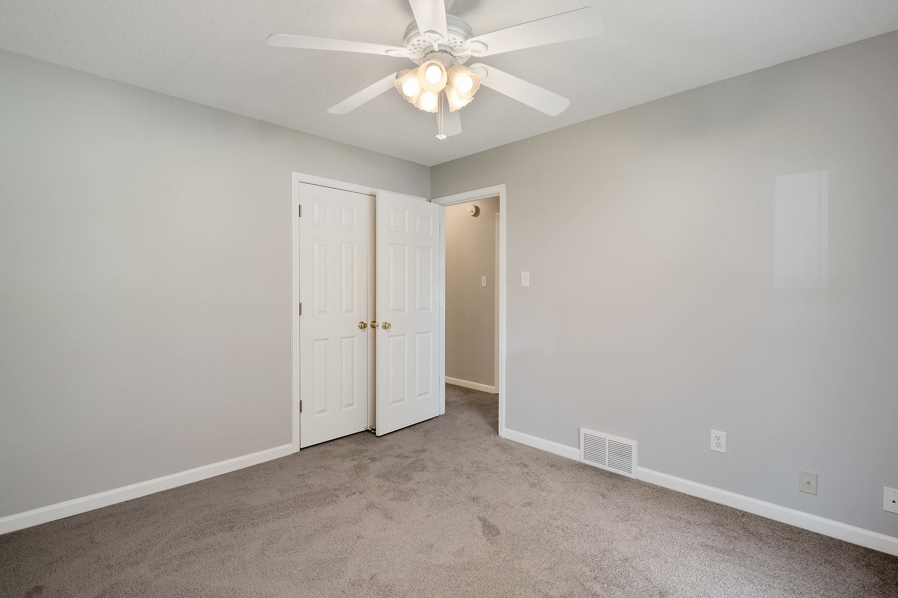 1171 Macon Hall Road Cordova, TN 38018 - Photo 23 of 35 an empty room with a chandelier fan and closet area