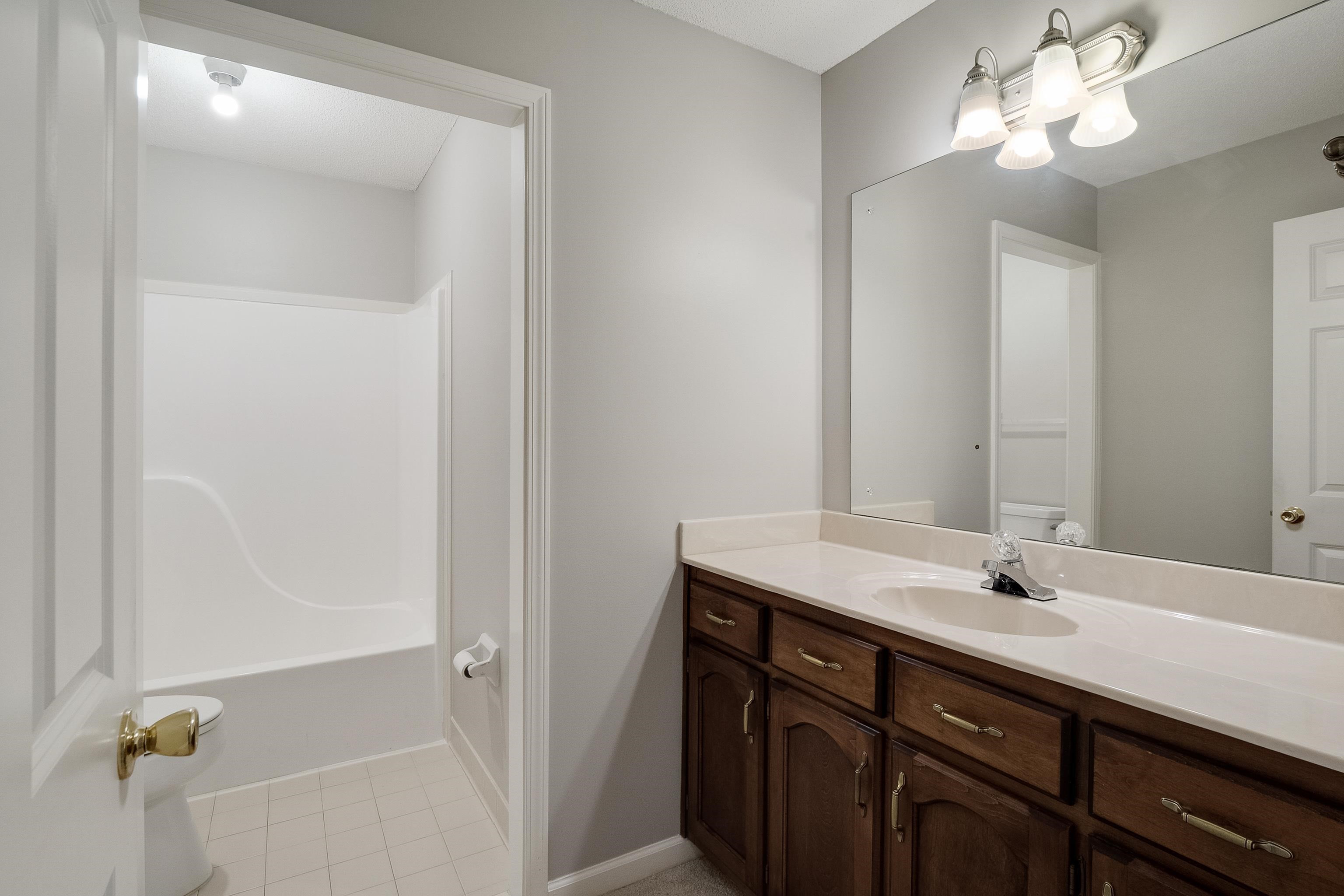 1171 Macon Hall Road Cordova, TN 38018 - Photo 24 of 35 a bathroom with a sink vanity and a mirror