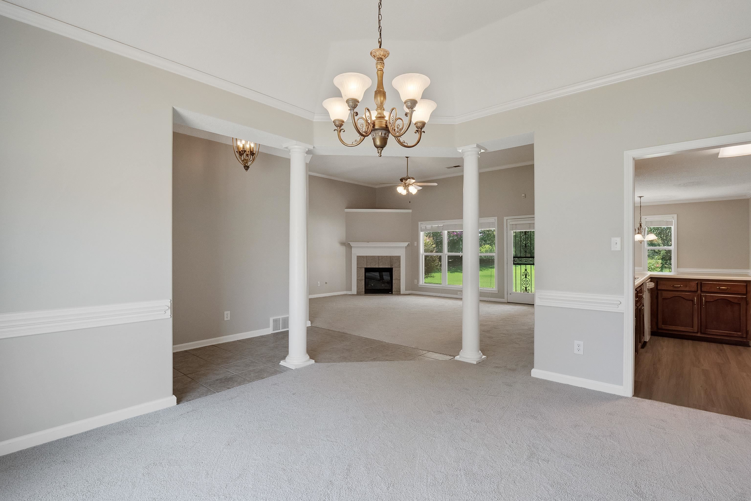 1171 Macon Hall Road Cordova, TN 38018 - Photo 5 of 35 a view of an empty room with a fireplace and a chandelier