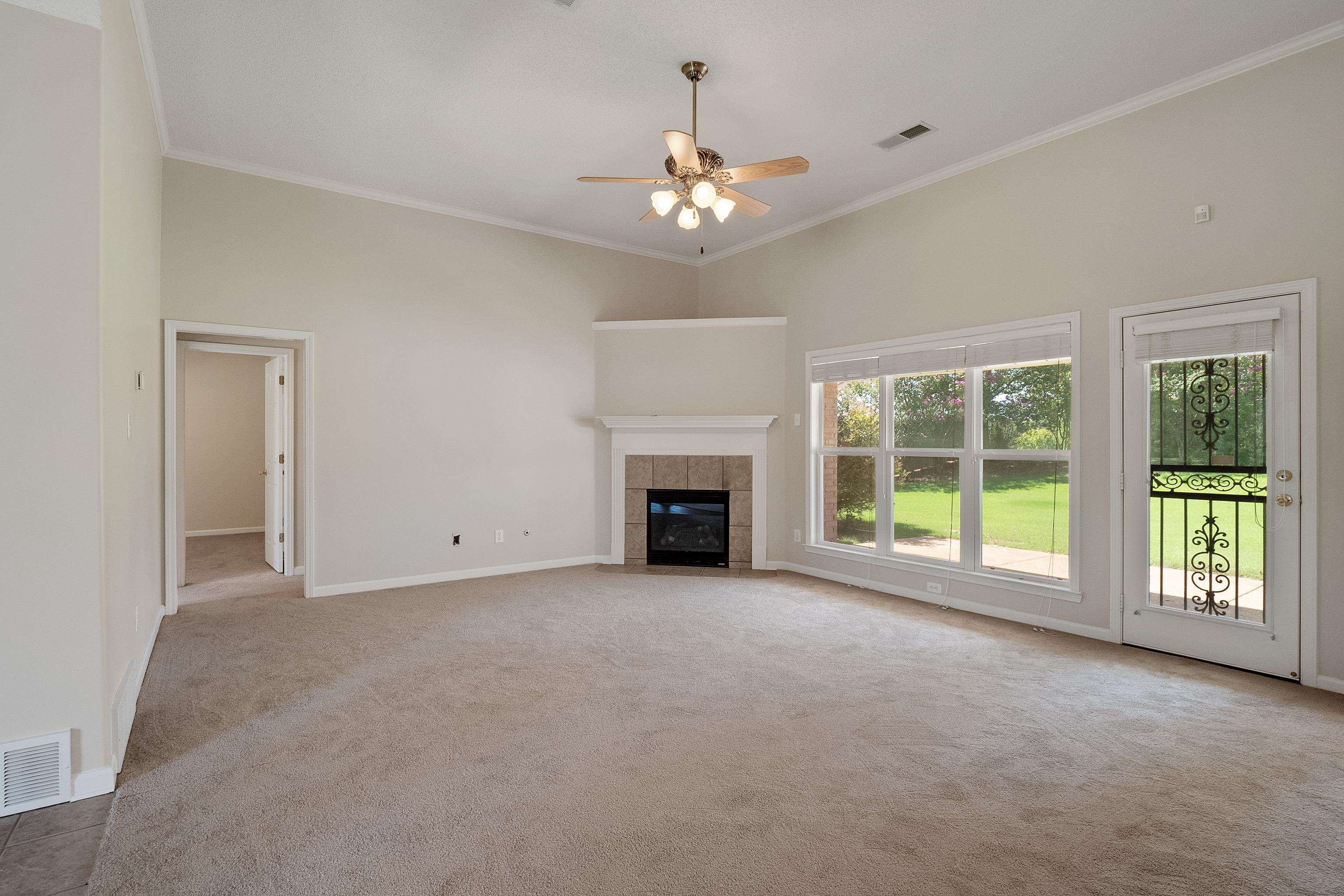 1171 Macon Hall Road Cordova, TN 38018 - Photo 6 of 35 a view of an empty room with a fireplace and a large window