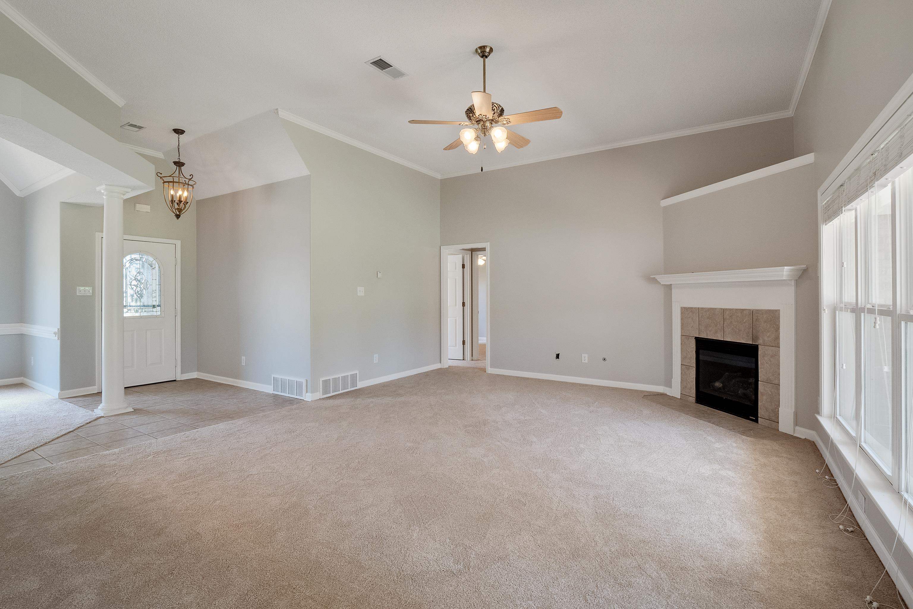 1171 Macon Hall Road Cordova, TN 38018 - Photo 7 of 35 an empty room with chandelier fan and fireplace