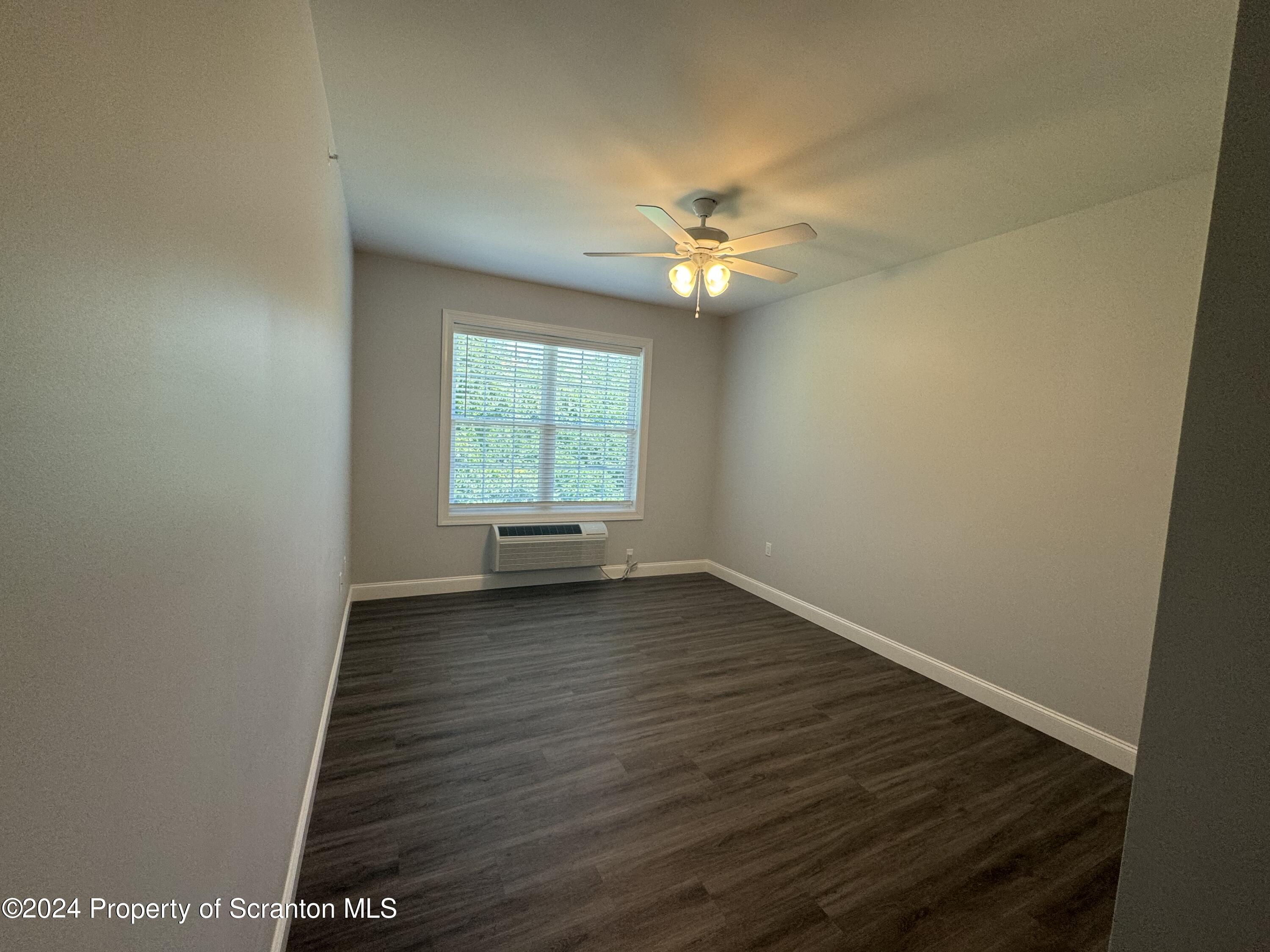 104 Circle Drive Taylor, PA 18517 - Photo 14 of 31 an empty room with wooden floor and windows