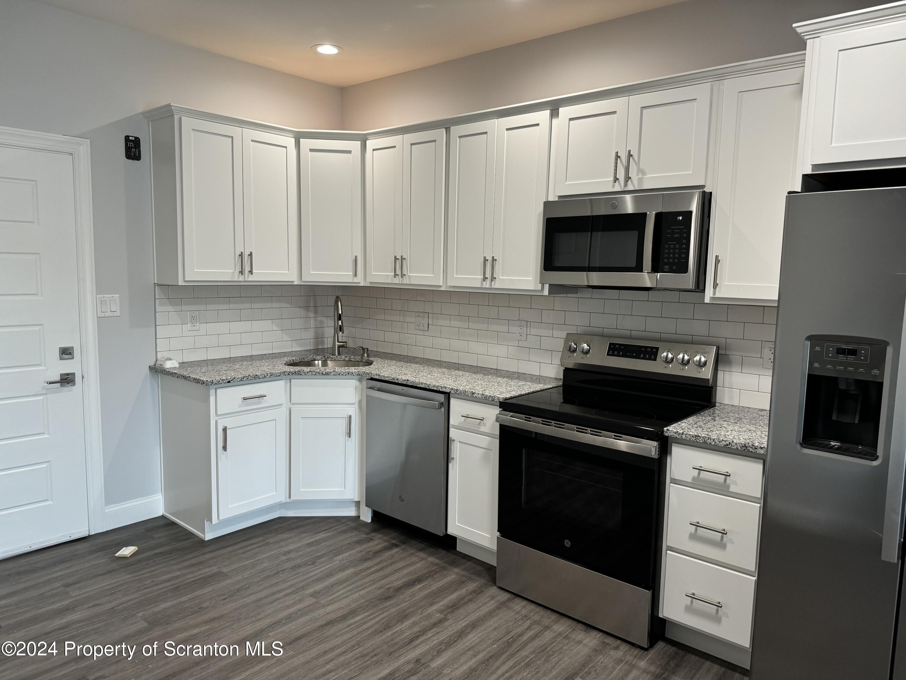 104 Circle Drive Taylor, PA 18517 - Photo 3 of 31 a kitchen with stainless steel appliances granite countertop a stove a sink and a microwave