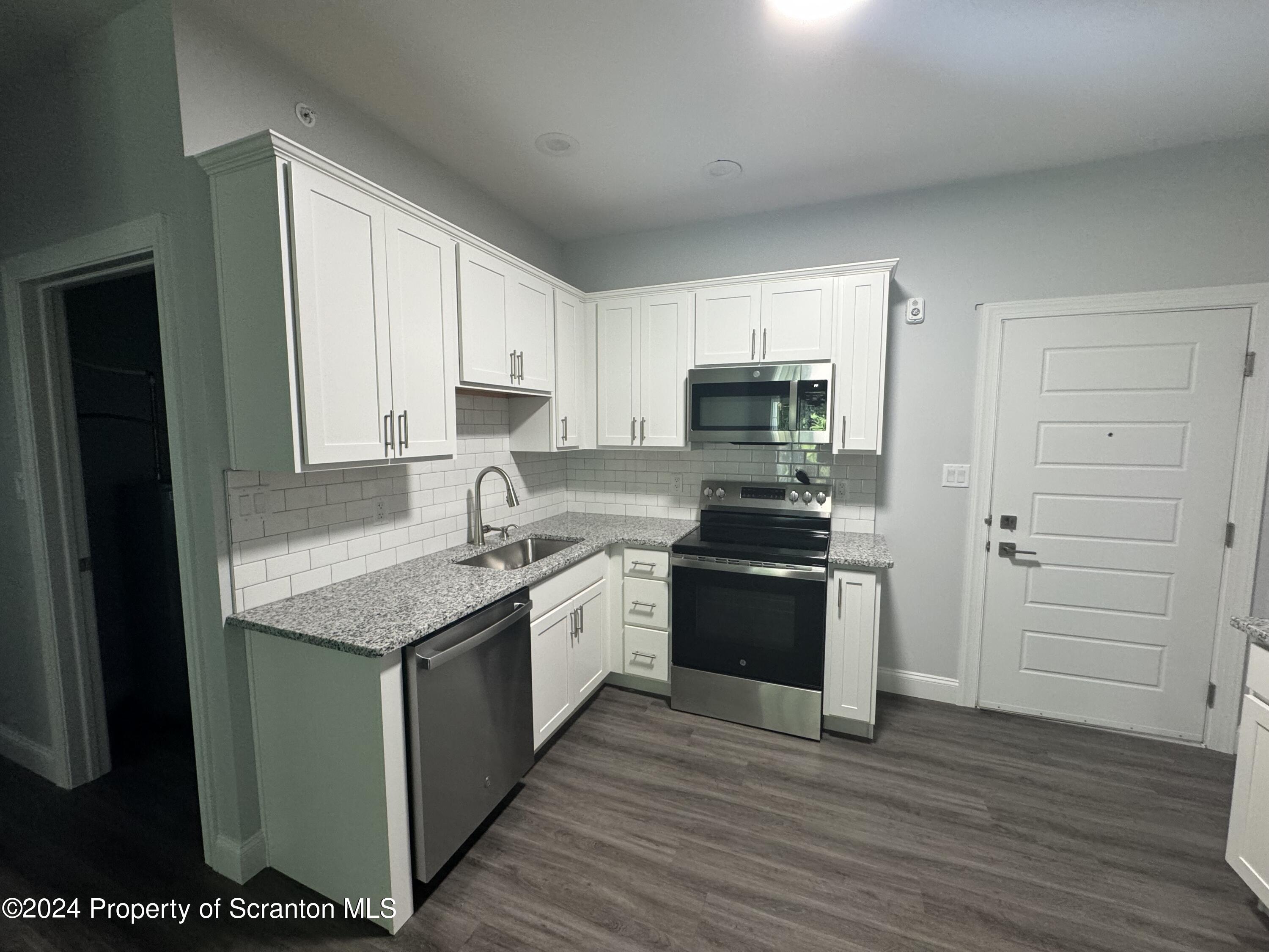 104 Circle Drive Taylor, PA 18517 - Photo 4 of 31 a kitchen with stainless steel appliances granite countertop a stove and a sink
