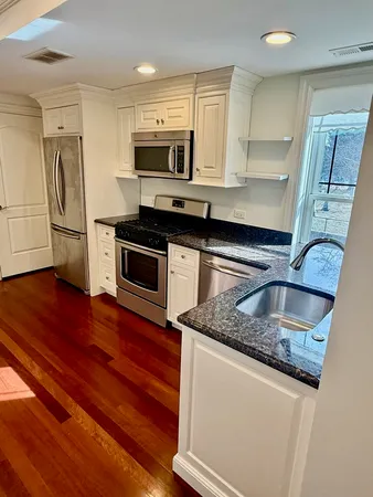 a kitchen with stainless steel appliances granite countertop a sink a stove and a microwave