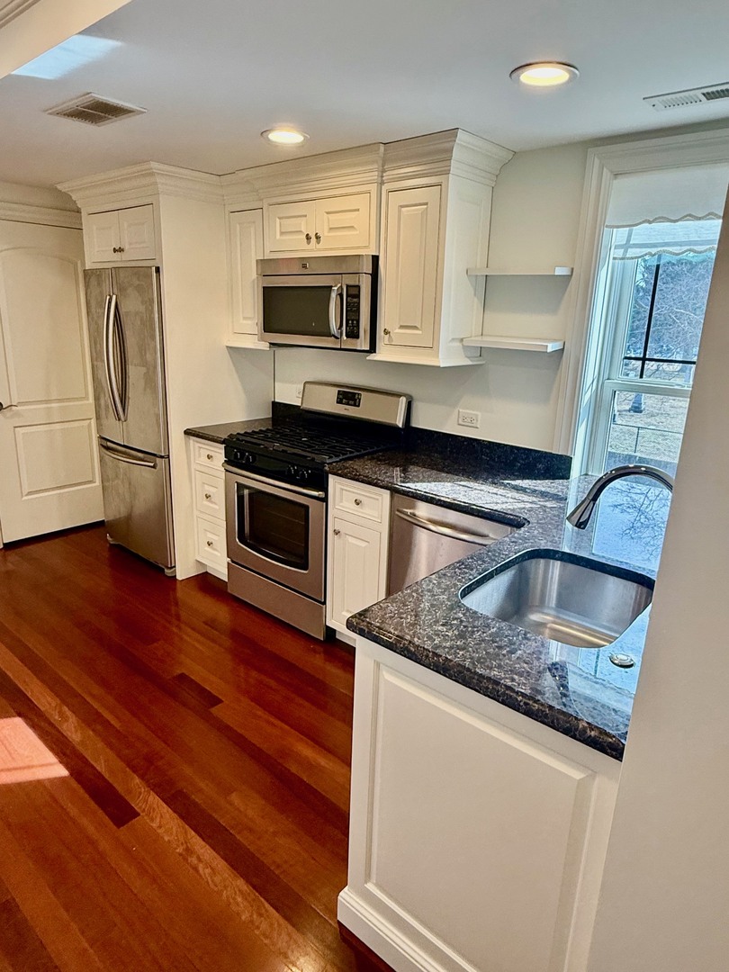 1000 Ridge Road, Unit 2 Wilmette, IL 60091 - Photo 3 of 11 a kitchen with stainless steel appliances granite countertop a sink a stove and a microwave