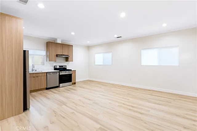 a large kitchen with kitchen island a sink stainless steel appliances and cabinets