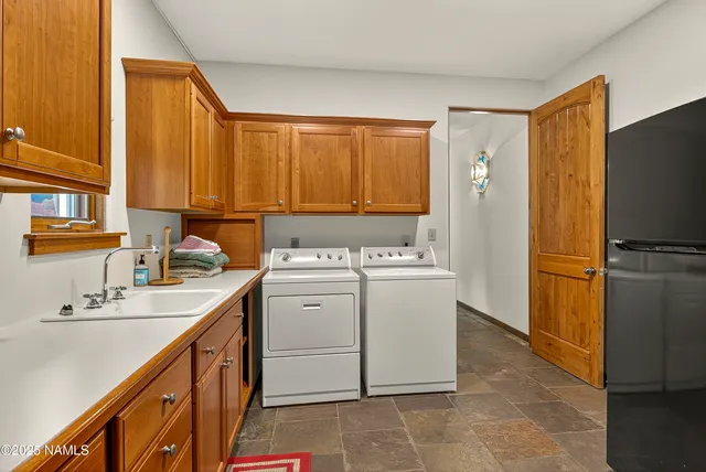 a utility room with cabinets washer and dryer