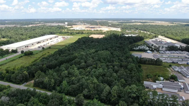 an aerial view of ocean and residential houses with outdoor space