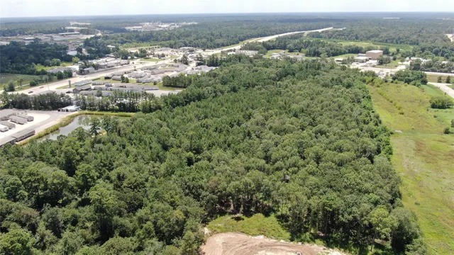 an aerial view of a houses with a yard and mountain view in back