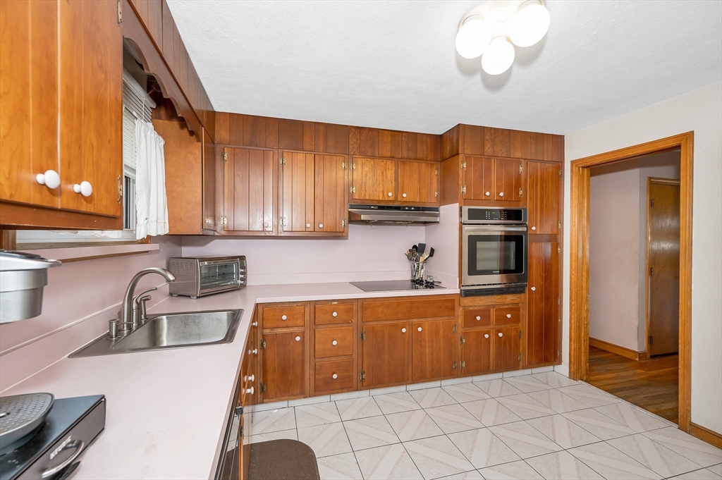 303 Walnut Street Saugus, MA 01906 - Photo 13 of 41 a kitchen with wooden cabinets and a sink