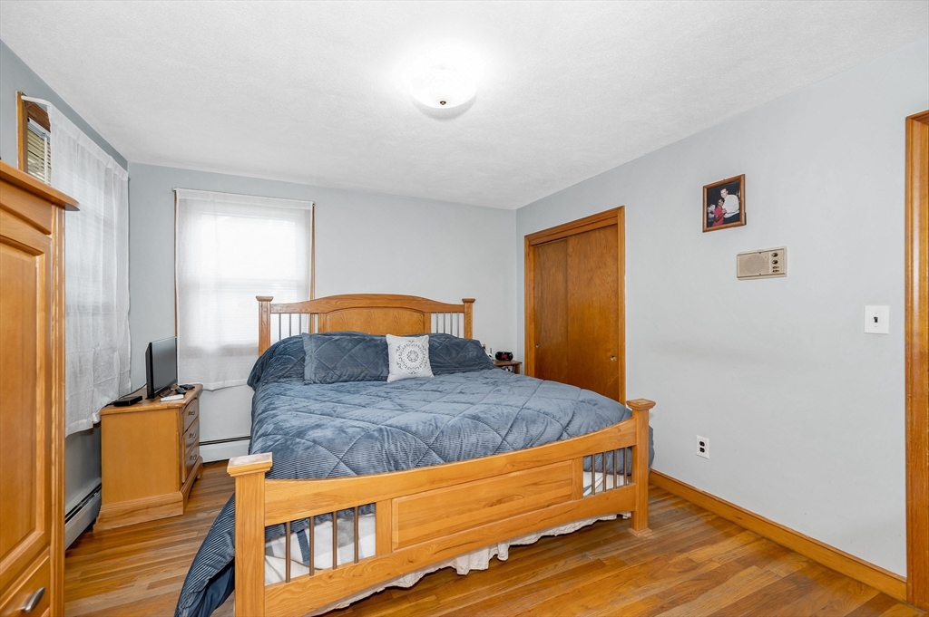 303 Walnut Street Saugus, MA 01906 - Photo 22 of 41 a bedroom with a bed and wooden floor