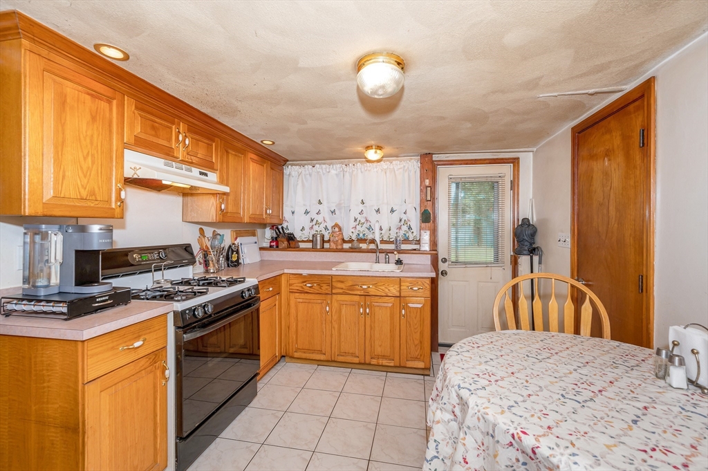 303 Walnut Street Saugus, MA 01906 - Photo 27 of 41 a kitchen with stainless steel appliances granite countertop a stove top oven a sink dishwasher and cabinets with wooden floor