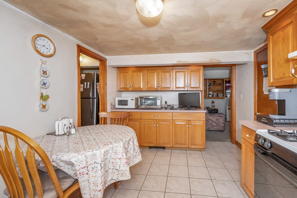 303 Walnut Street Saugus, MA 01906 - Photo 28 of 41 a kitchen with kitchen island granite countertop a stove a sink dishwasher and a refrigerator with wooden floor