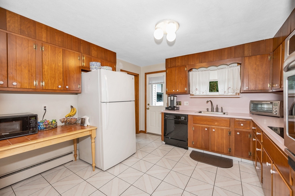 303 Walnut Street Saugus, MA 01906 - Photo 10 of 41 a kitchen with stainless steel appliances granite countertop a refrigerator a stove a sink and a microwave
