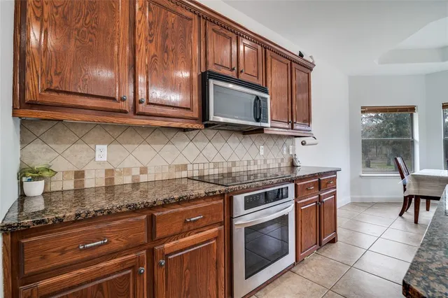 a kitchen with granite countertop cabinets stainless steel appliances and a counter space