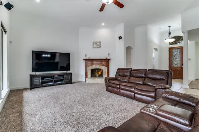 a living room with furniture a flat screen tv and a fireplace