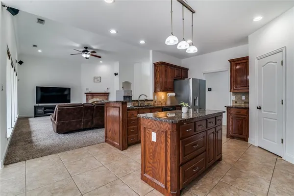 a kitchen with kitchen island granite countertop a sink counter top space appliances and cabinets