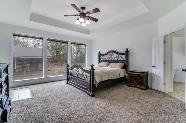 a bed sitting in a spacious bedroom next to a window