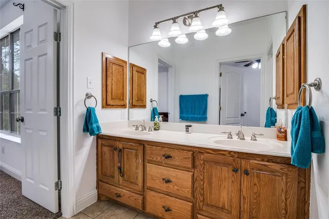 a spacious bathroom with a double vanity sink a large mirror and a shower