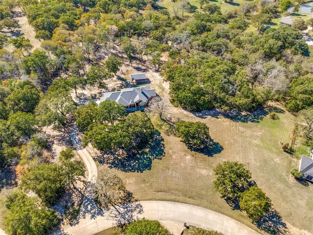 an aerial view of house with yard and mountain view in back