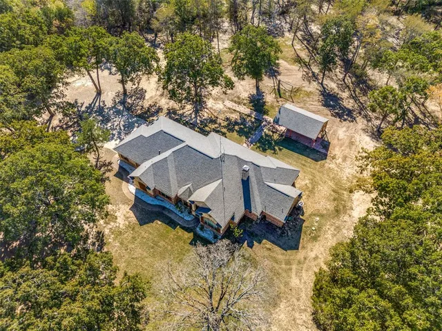 an aerial view of a house with a yard and trees