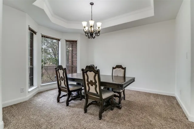 a view of a dining room with furniture and a chandelier