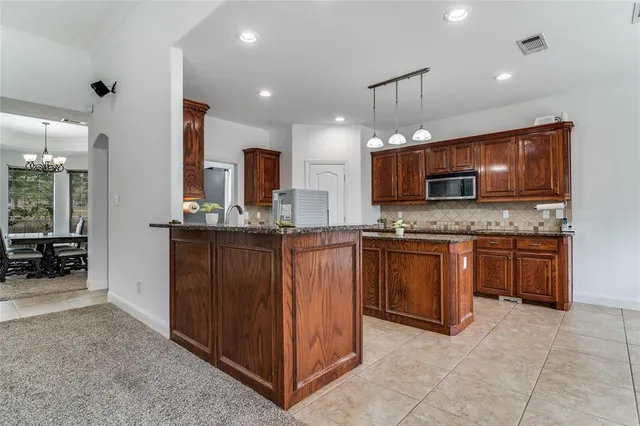 a kitchen with kitchen island granite countertop wooden cabinets stainless steel appliances and a counter top