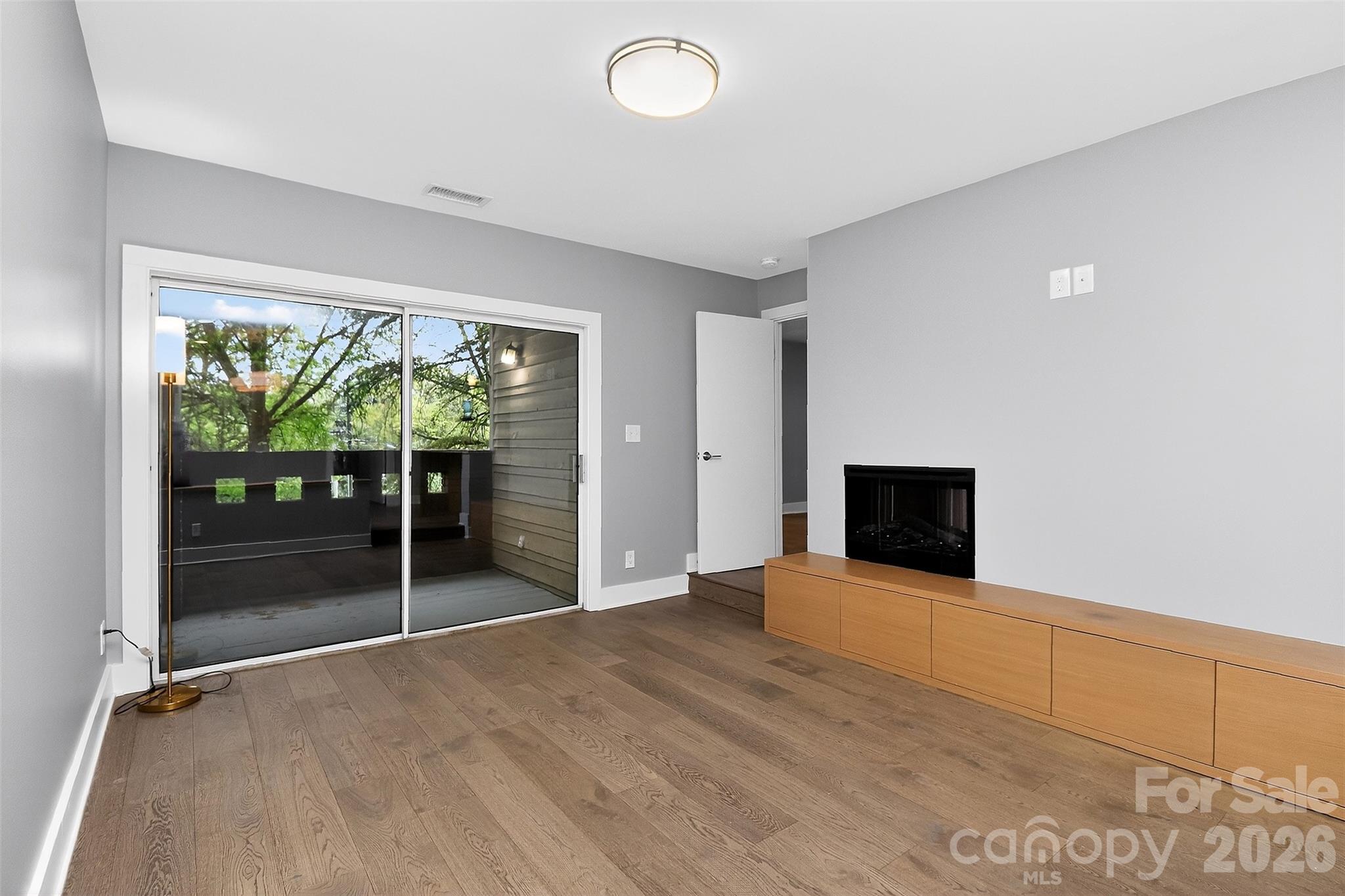 603 Queens Road, Unit B Charlotte, NC 28207 - Photo 15 of 33 a view of an empty room with wooden floor and a window
