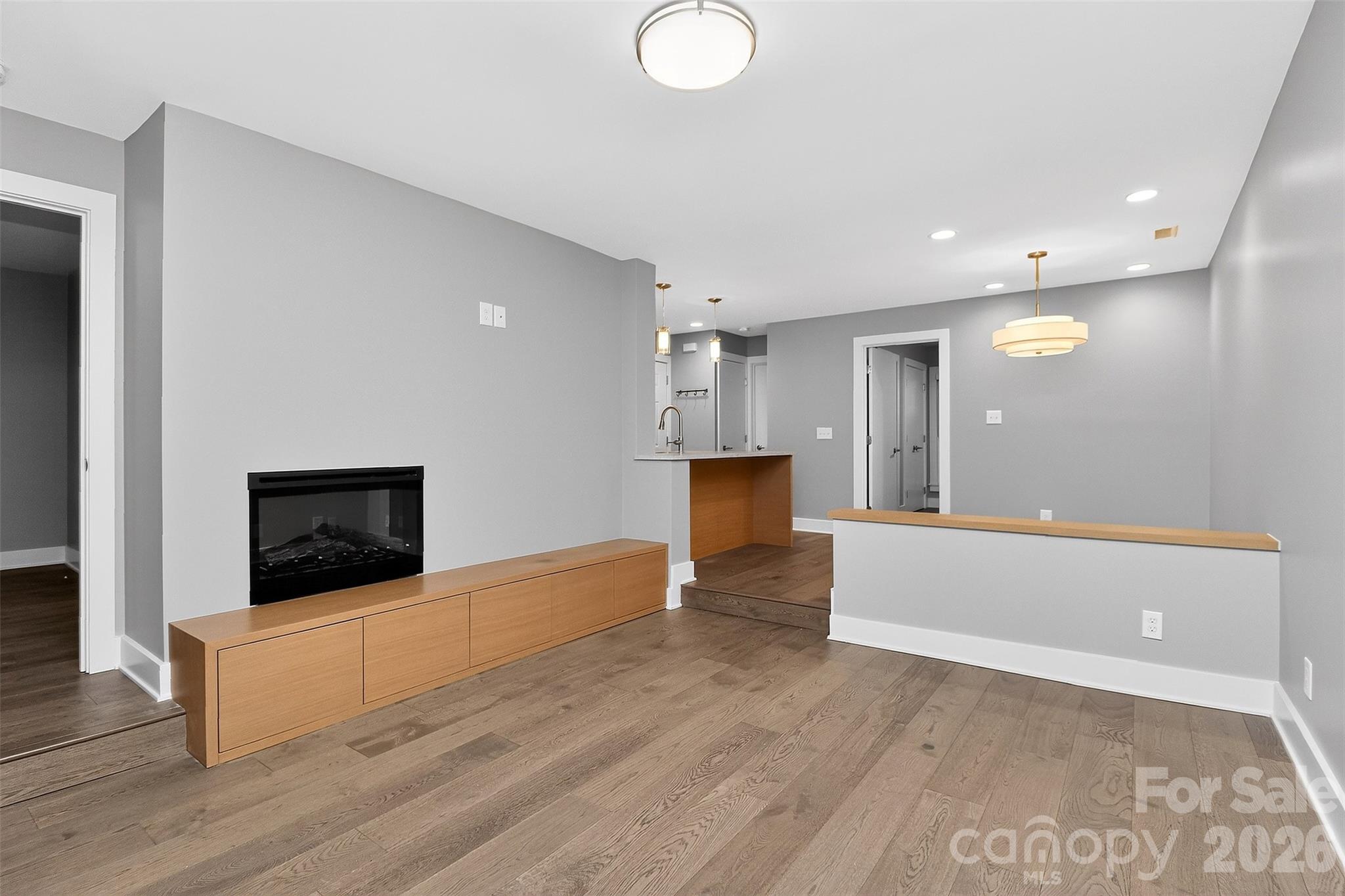 603 Queens Road, Unit B Charlotte, NC 28207 - Photo 16 of 33 a view of an empty room with wooden floor and a kitchen