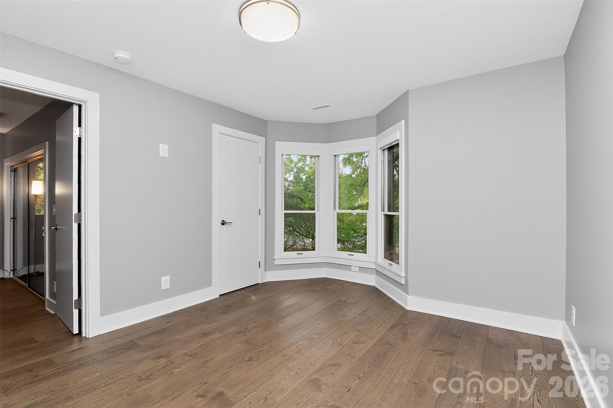 603 Queens Road, Unit B Charlotte, NC 28207 - Photo 18 of 33 a view of an empty room with wooden floor and a window
